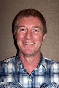 Photo of Don Johnston wearing a checkered shirt.