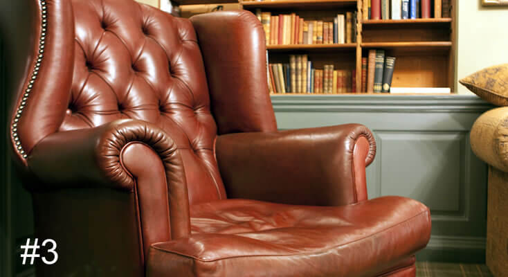 Photo of an old leather armchair in front of a bookcase