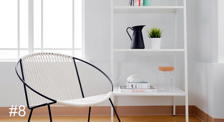 Photo of white room with a white chair and some shelves