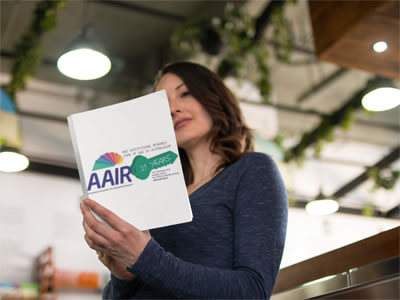 Photo of a woman reading a book with the AAIR Annual Forum 2010 logo on it