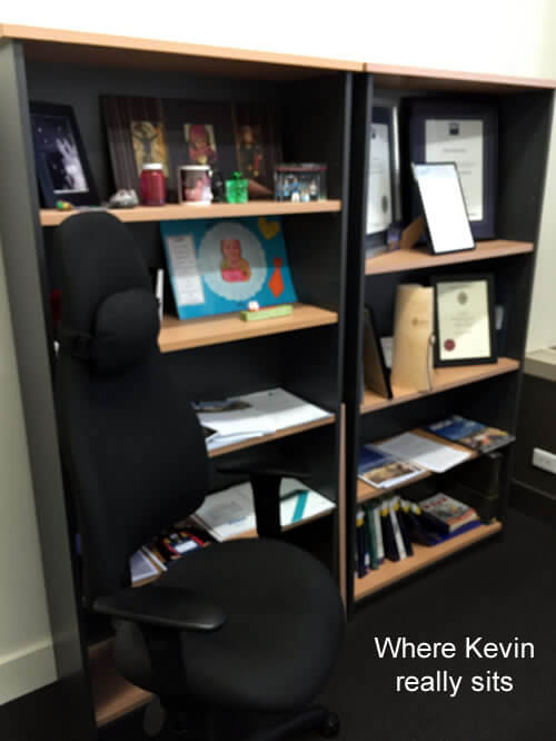 Photo of Kevin Maley's office chair with bookshelves in the background