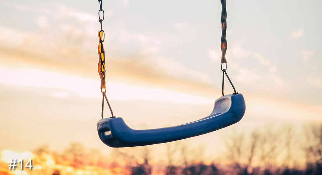 Photo of a swing with a sunset in the background