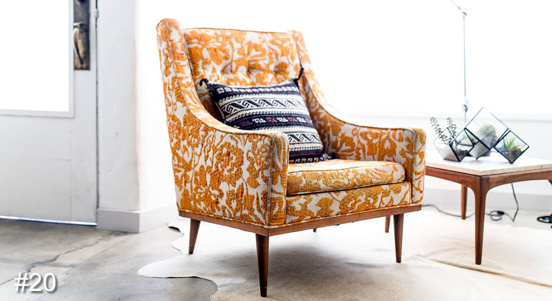 Photo of a brocade chair with a cushion on it