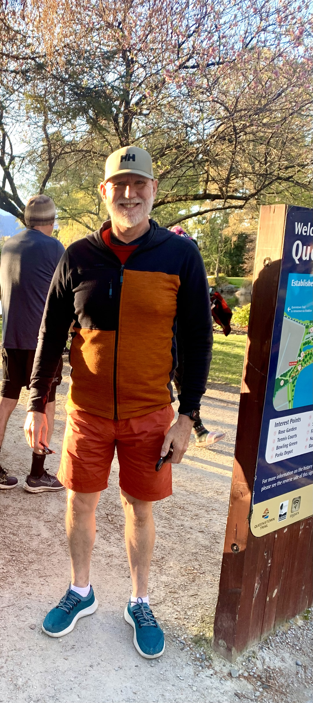 Photo of Stuart Terry at Park Run in Queenstown New Zealand. He is standing next to a map sign board outdoors.